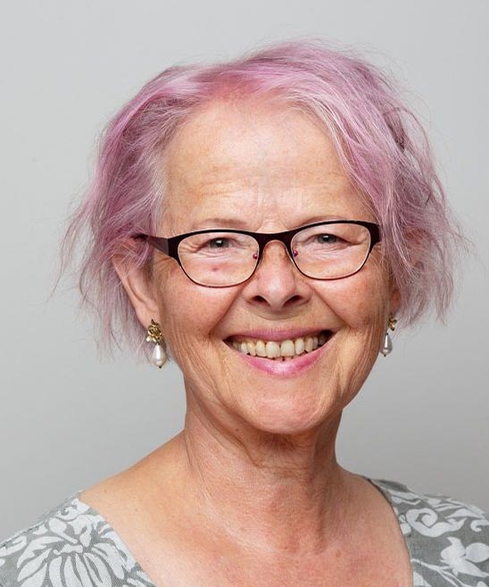 Portait of a senior woman with pink hair, smiling